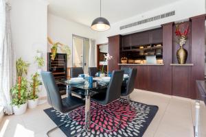 een eetkamer met een glazen tafel en zwarte stoelen bij Incredible Fountain Views 2.5 BR Burj Residences in Dubai