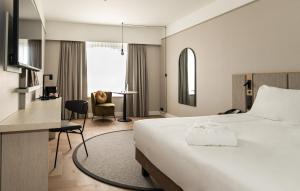 a hotel room with a bed and a desk at Mercure Liege City Centre in Liège