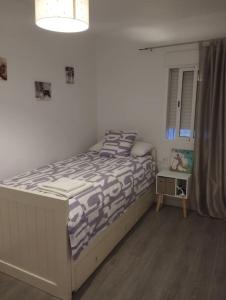 1 dormitorio con 1 cama y ventana en una habitación en Apartamento acogedor. en Gelves