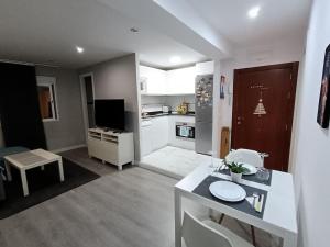 a kitchen and a living room with a table and a kitchen at Apartamento acogedor. in Gelves