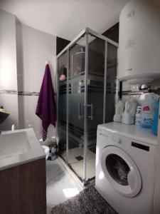 a bathroom with a washing machine and a sink at Apartamento acogedor. in Gelves