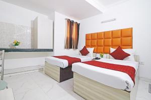 1 dormitorio con 2 camas con sábanas rojas y blancas en The Iconic Delhi Airport by Midway en Nueva Delhi