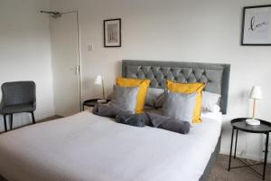 a bedroom with a large white bed with yellow pillows at The Live and Let Live in Downham Market