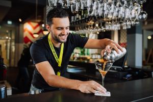 a bartender making a drink at a bar at Stayokay Hostel Amsterdam Oost in Amsterdam