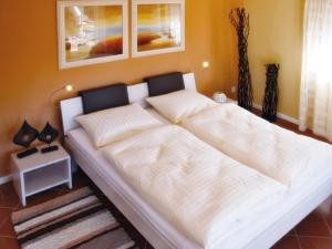 a large white bed in a room with at Scanhausvilla in Wustrow