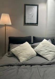 Una cama con dos almohadas encima. en Luxurious Studio with Lake View near Zurich, en Uetikon am See
