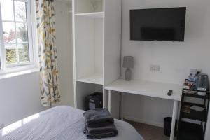 a bedroom with a bed and a tv on a wall at The Live and Let Live in Downham Market