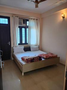a bedroom with a large bed with a window at The Anand with Ganga View and Rooftop Cafe in Rishīkesh