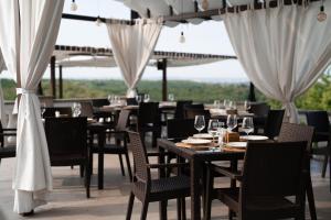 a restaurant with tables and chairs with wine glasses at Sobor Family Resort in Stavcheny