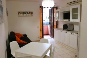 a living room with a white table and a kitchen at Azzurra in Marciana Marina