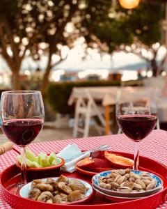 a table with two glasses of red wine and food at Cagla Hotel in Ildır