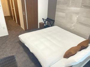 a bed in a hospital room with a white bedsheet at COCOSTAY銀山町リバーサイド,COCOSTAY Kanayamacho riverside, Great location river view-5 min walk from the nearest station in Hiroshima