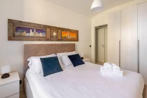 アルバにあるCasa Regina 3, nel centro di Alba!の大きな白いベッドと青い枕のある寝室 +4枚の写真