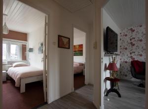 a bedroom with two beds and a television in it at Boxtel, Appartement (1-4p) nabij station/centrum in Boxtel