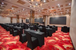 a conference room with black tables and chairs and a screen at The Mirah Bogor in Bogor
