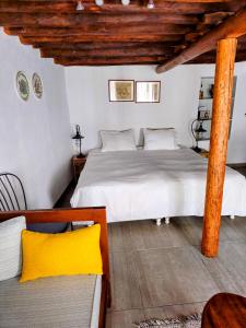 una camera da letto con un letto bianco e un soffitto in legno di Keresbino Hydra Art Suite a Hydra