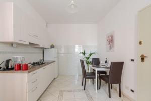 a kitchen with a table and chairs in a kitchen at Casa Regina 2, nel centro storico di Alba! in Alba