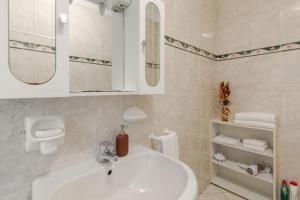 a white bathroom with a sink and a mirror at Casa Regina 2, nel centro storico di Alba! in Alba
