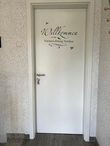 a white door with a sign on top of it at Ferienwohnung Nordsee in Pewsum
