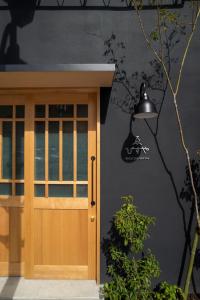 dom z drewnianymi drzwiami i lampą w obiekcie Ebisuya / Vacation STAY 5851 w mieście Kōfu