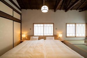 ein großes Bett in einem Zimmer mit zwei Fenstern in der Unterkunft Ebisuya / Vacation STAY 5851 in Kofu