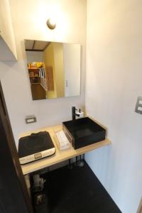 W łazience znajduje się umywalka i lustro. w obiekcie Ebisuya / Vacation STAY 5851 w mieście Kōfu