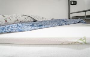 a bed with a blue and white comforter and pillows at HouseInGenoaCenter2 Parking in Genova