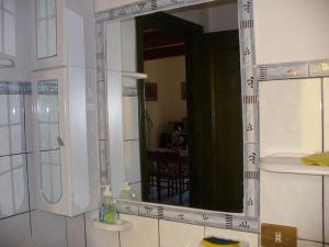 a bathroom with a large mirror and a sink at Accogliente Appartamento a pochi passi dal mare in Funtana Meiga