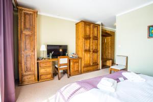 a bedroom with a bed and a desk with a computer at Sojka Resort - Hotel & Drevenice in Bešeňová