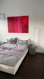 a bedroom with a bed with a painting on the wall at Ferienhaus Rolf in Peterswald-Löffelscheid +8 photos