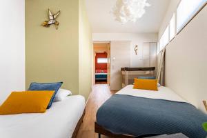 a bedroom with two beds with yellow and blue pillows at Fully furnished house for families with infants. in Osaka
