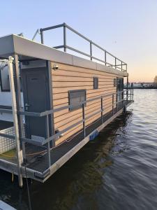 ein Haus auf einer Anlegestelle am Wasser in der Unterkunft Ferienwohnung auf dem See in Neuruppin