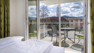 1 dormitorio con 1 cama y balcón con vistas. en Haus am Krummbach, en Kirchzarten