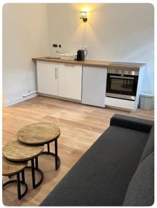 une cuisine avec un canapé, deux tables et un comptoir dans l'établissement L'Ambre, à Angers