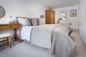a bedroom with a large bed with a wooden desk at Wharton Cottage, Lake District Retreat in Cartmel