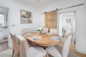 a dining room with a wooden table and chairs at Wharton Cottage, Lake District Retreat in Cartmel