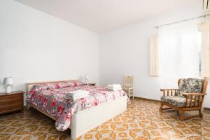1 dormitorio con 1 cama y 1 silla en Casa vacanza nel centro di Irgoli, en Irgoli