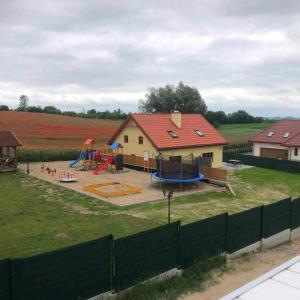 a house with a playground in a field at Domek Mikołajki in Mikołajki