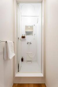 a white bathroom with a shower and a sink at Fully furnished house for families with infants. in Osaka