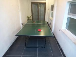 una mesa de ping pong con dos pelotas de ping pong. en Rose huisje, en Amberes