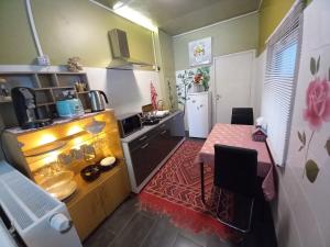 uma pequena cozinha com uma mesa e uma pequena cozinha com um balcão em Rose huisje em Antuérpia