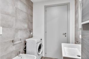 a bathroom with a washing machine and a sink at Appartamento Mango - Affitti Brevi Italia in Lecco +7 photos