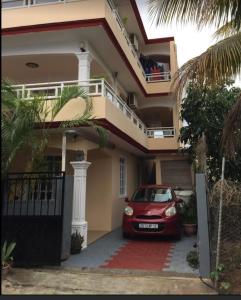 a red car parked in front of a house at Tonishka Villa in Trou aux Biches