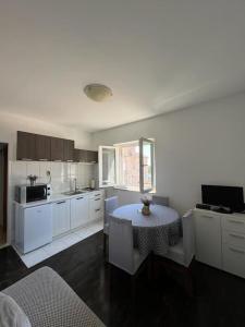 cocina con mesa y cocina con armarios blancos en Apartment Antonijo en Hvar