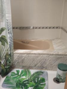 a bathroom with a tub and a green plant at MOAMA Beach in Costa Teguise