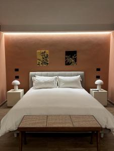 a bedroom with a large white bed with two lamps at Raha Suites in Syracuse