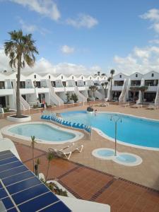 a large swimming pool in a resort with buildings at MOAMA Beach in Costa Teguise