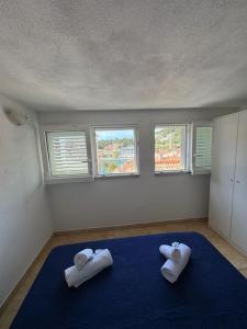 Habitación con 1 cama azul y 2 toallas blancas. en Apartment Antonijo en Hvar