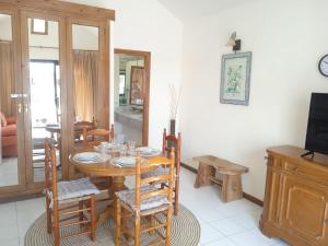 a dining room with a wooden table and chairs at MOAMA Beach in Costa Teguise