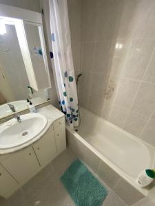ein weißes Bad mit einem Waschbecken und einer Dusche in der Unterkunft Appartement Spacieux proche commerces et plage Centre-Ville in Roses